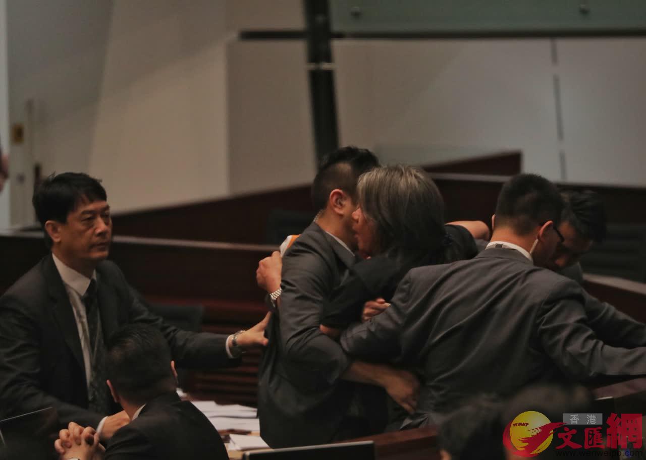 立法會議員梁國雄衝出座位投擲紙張，被逐出會議廳