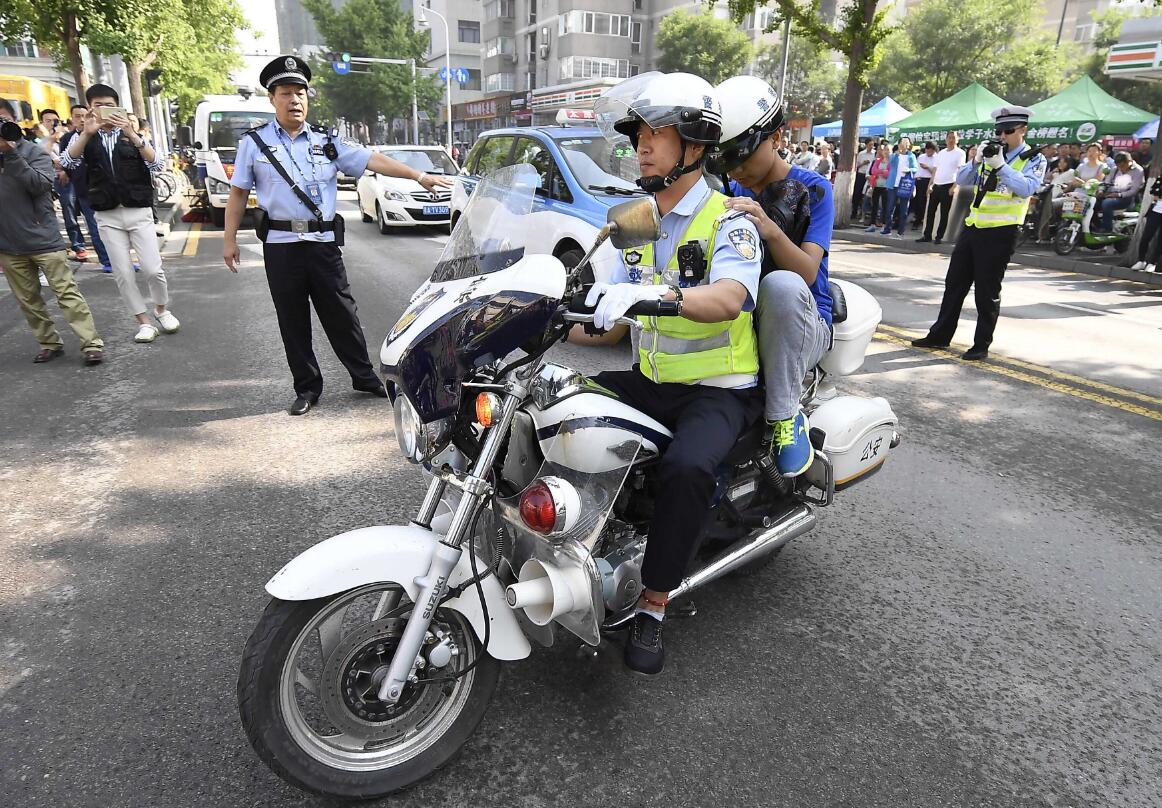 山西太原交警护送一名忘带准考证的考生进考点（中新社）