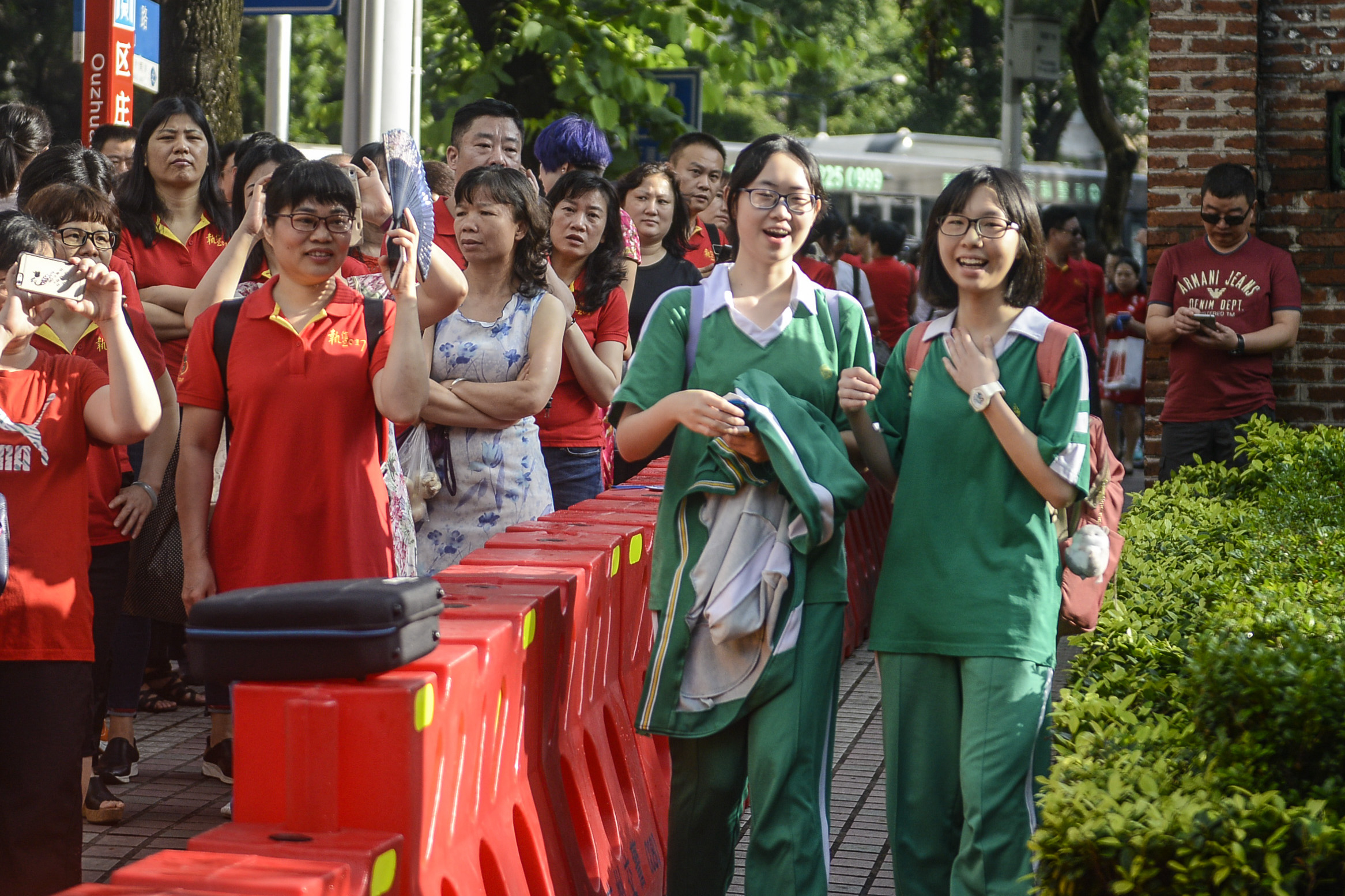 广州某中学门口，考生面带笑容步入考场（中新社）