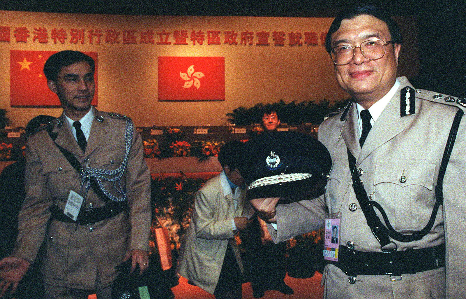 1997年7月1日凌晨，香港警务处处长许淇安（右）换上新警徽 （新华社）