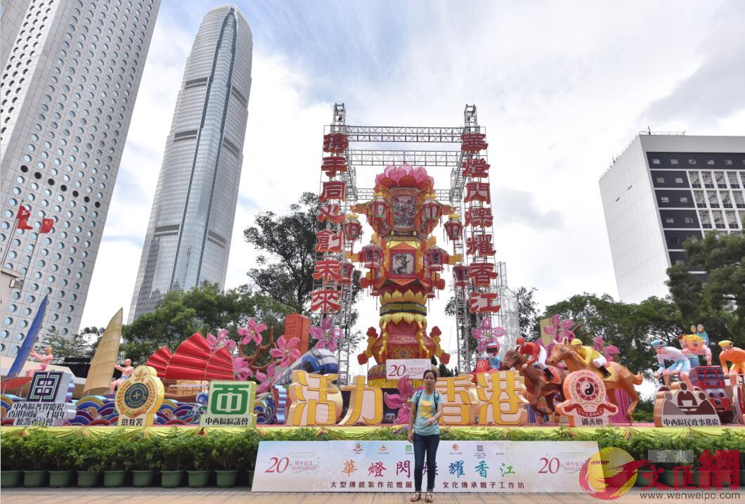 中环，游客在一座庆祝香港回归20周年主题花灯前留影