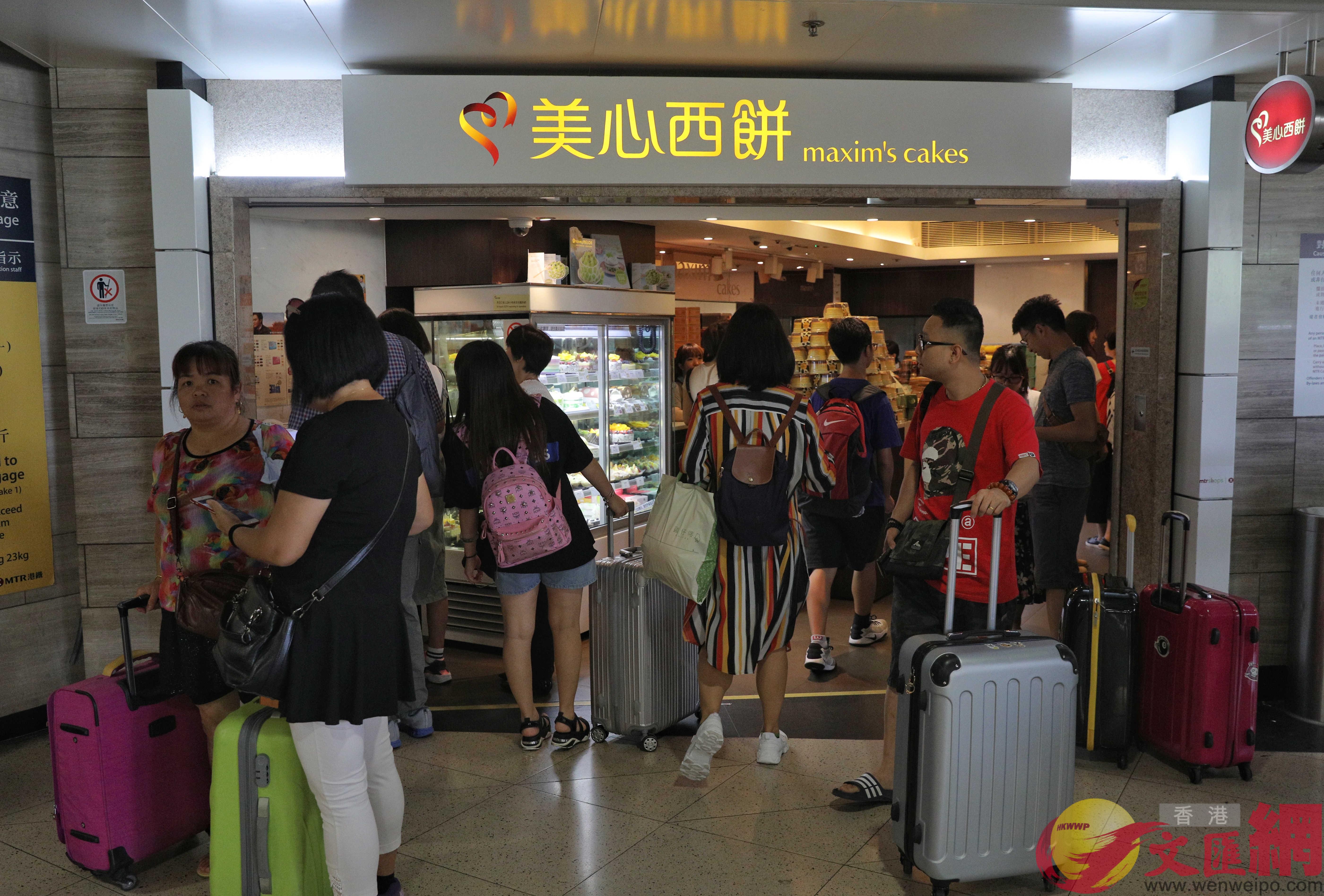 部分内地旅客拖行李箱来饼店购物