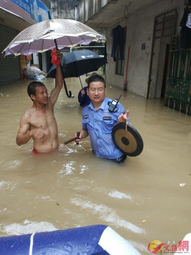 在珠海，民警敲锣呼吁群众转移到安全地带。珠海警方供图。