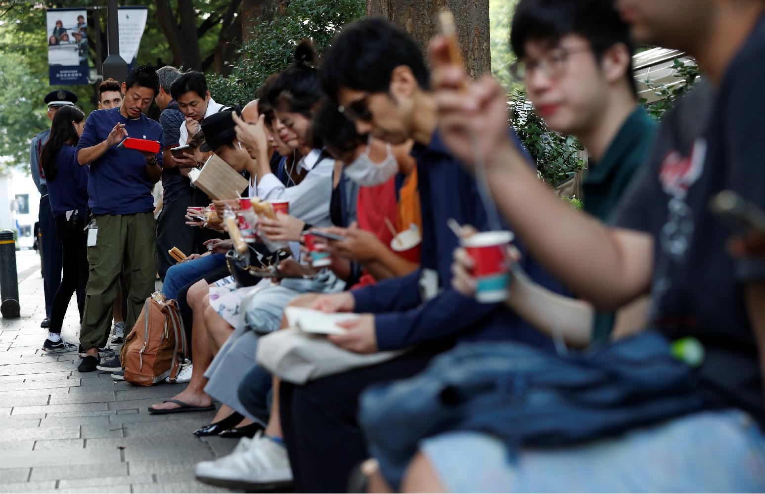 东京，「果粉」在专卖店外边排队边吃早餐(路透社)