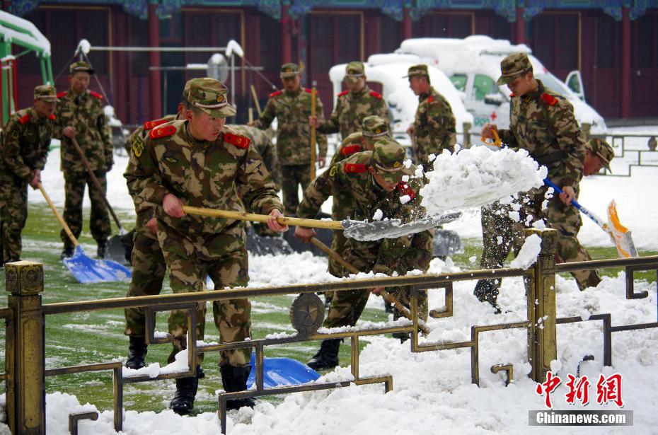  2013年3月20日，天安门国旗护卫队武警正在扫雪。当日恰逢春分，北京普降大雪，最大积雪深度超过20厘米。中新社