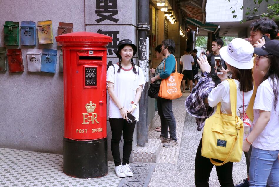 訪客在｢香港街市｣大門擺設的舊郵筒前留影