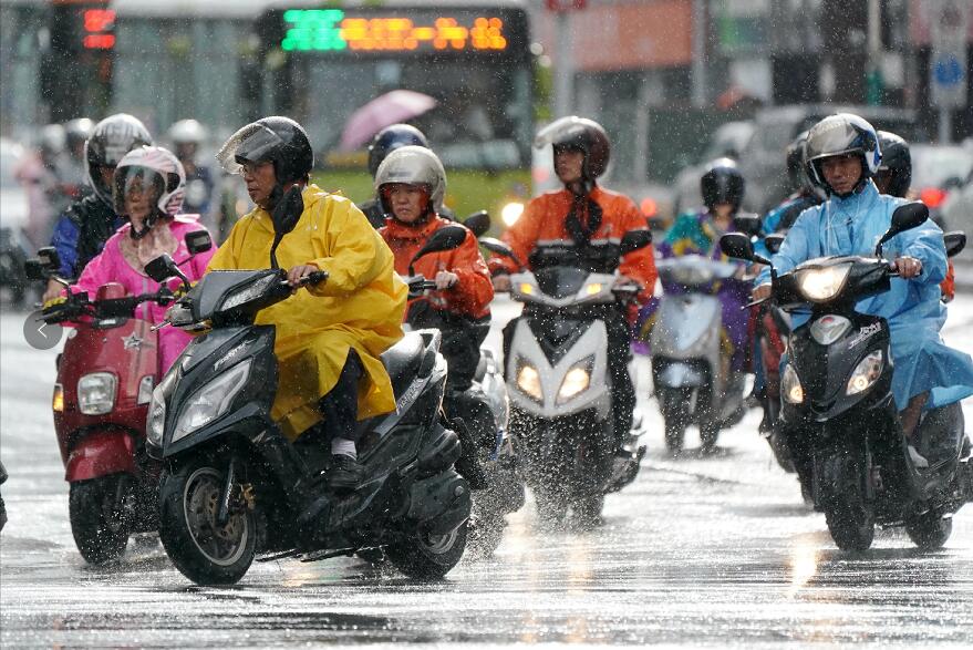 7月10日傍晚A台北市民冒雨騎電單車(中新社)