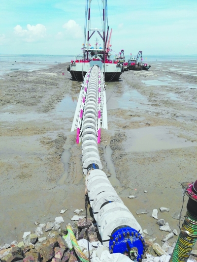 6月24日上午A在晉江金井灣A海上施工平台將一條長長的輸水管從岸邊徐徐拉伸A並固定在海底(中新網)