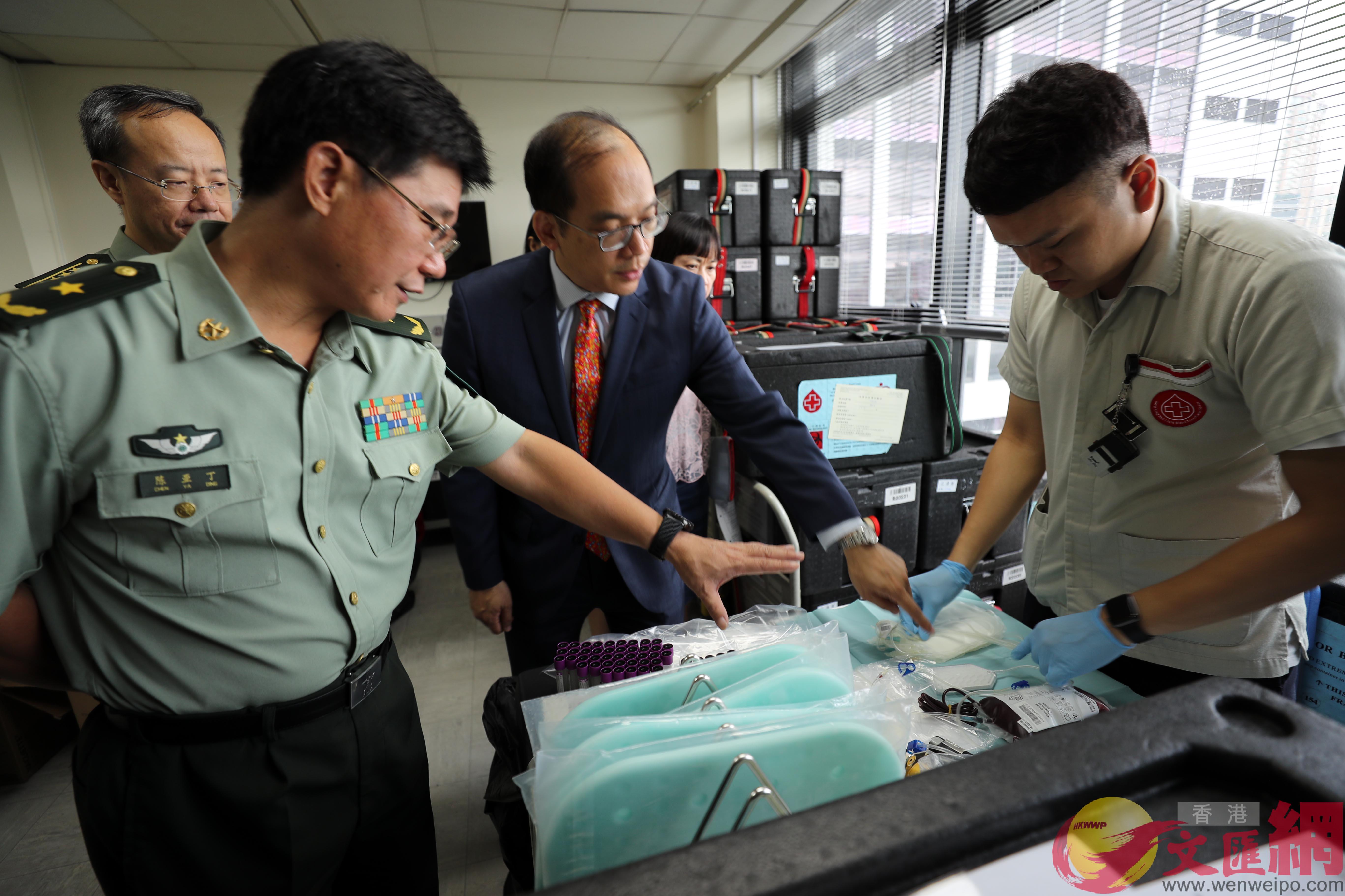 駐港部隊副政治委員陳亞丁少將(左)和香港紅十字輸血服務中心李卓廣醫生在了解採血情況C