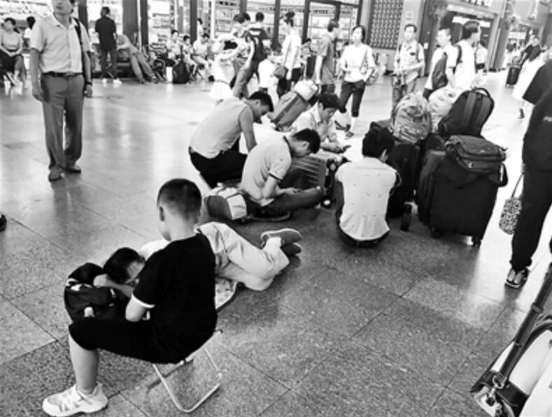 不少乘客坐在地上候車]北京青年報^