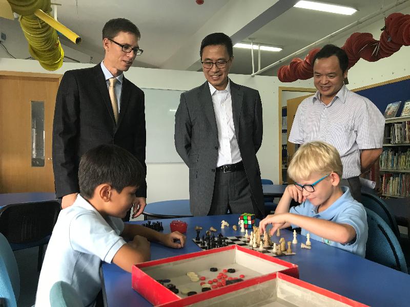 楊潤雄]中^和珠海市教育局局長林日團]右^在珠海國際學校觀看兩名學生下棋 
