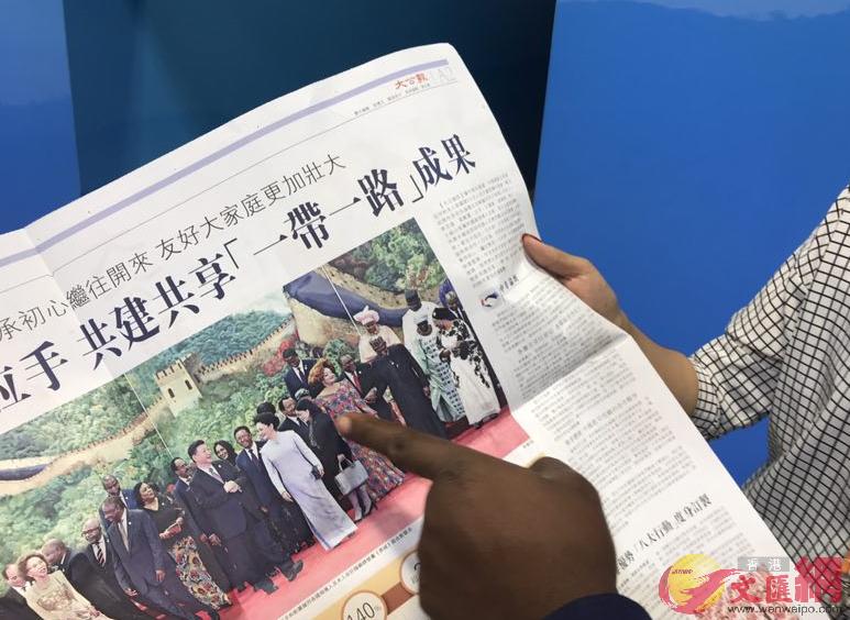 喀麥隆嘉賓指著m大公報n向中國朋友介紹喀麥隆國家的總統夫人 凱雷攝 
