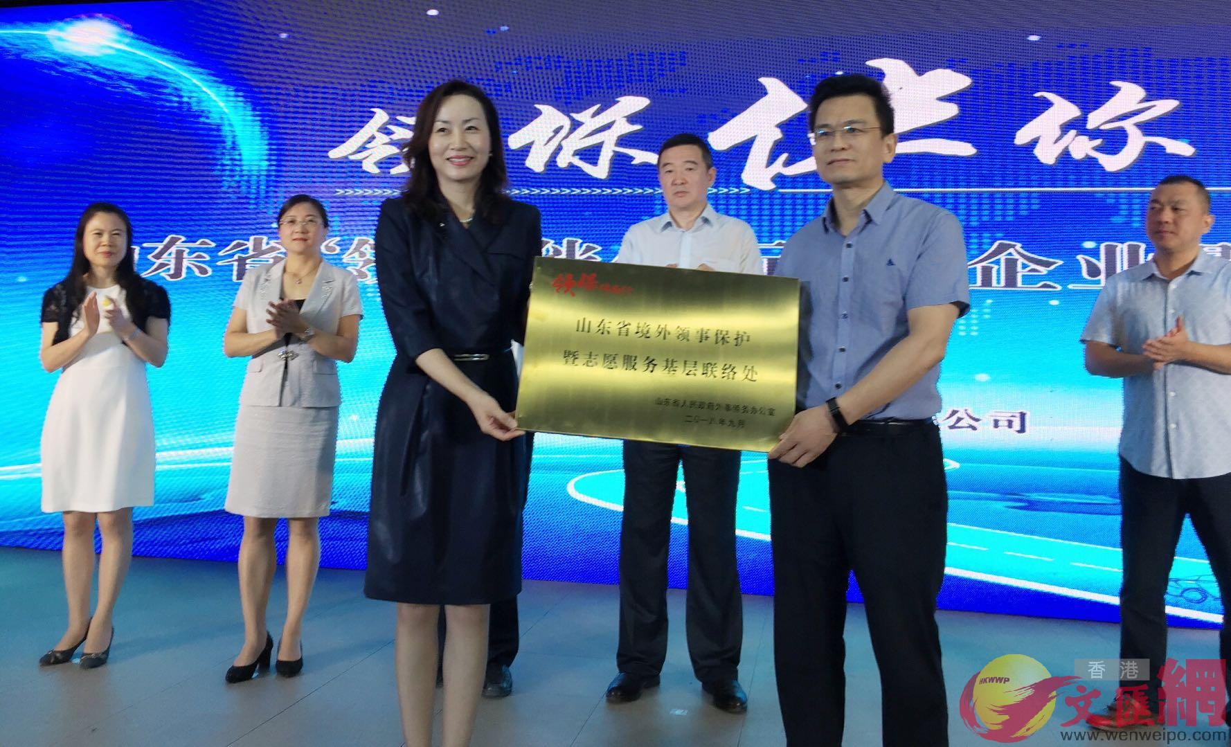 山東省外僑辦副主任陳白薇（左）為「基層聯絡處」授牌（記者楊奕霞攝）