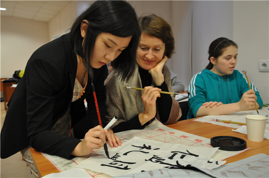 在孔子學院裡向中國志願者學習書法的俄羅斯人C