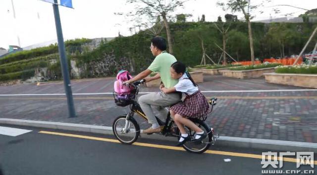 9月3日傍晚A鄧巍巍騎著電動自行車接女兒放學C央廣網