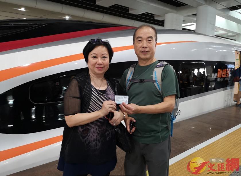 乘坐首列動感號高鐵G6582準點到達廣州南站的蔡先生夫婦在車頭合影]帥誠 攝^