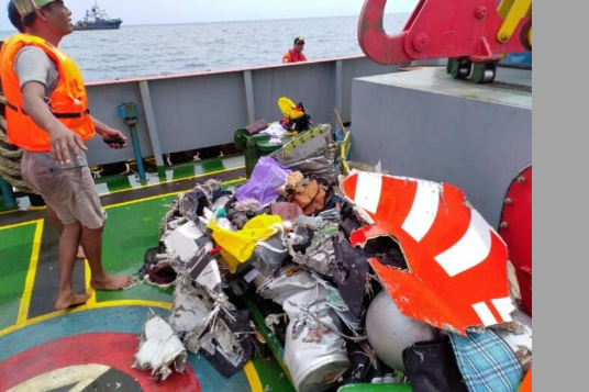 印尼救援部門在出事海域打撈起部分飛機殘骸]網絡圖片)