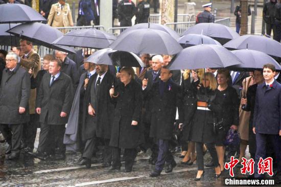 圖為法國總統馬克龍B德國總理默克爾B加拿大總理特魯多B歐盟委員會主席容克等政要在雨中共同走向凱旋門的儀式現場C]中新網^