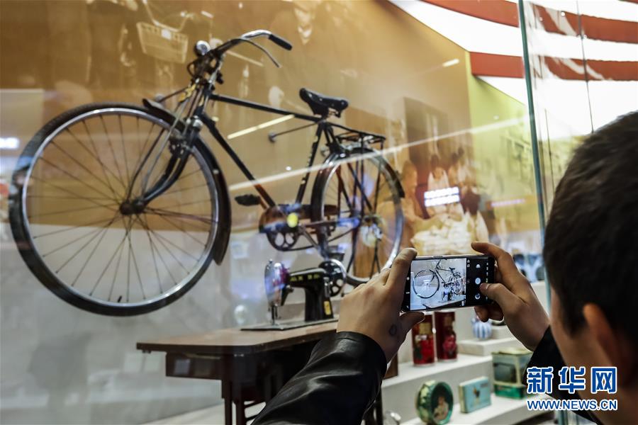 11月15日A在u歷史巨變v展區A一名參觀者在拍攝老式自行車和縫紉機C新華社