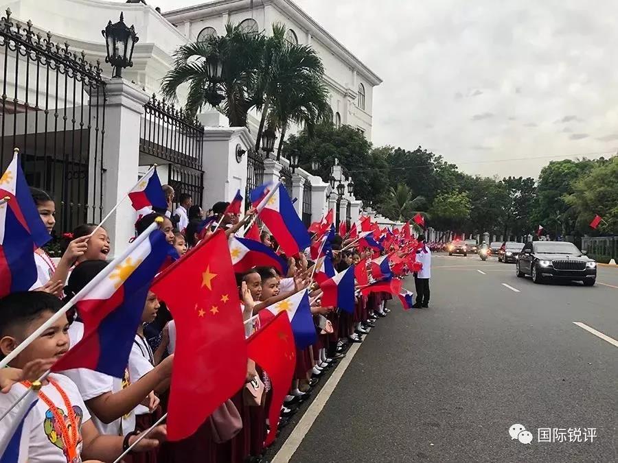 20日A來自馬尼拉當地三所小學的千名小學生站在總統府道路兩側揮舞兩國國旗A歡迎習主席車隊C