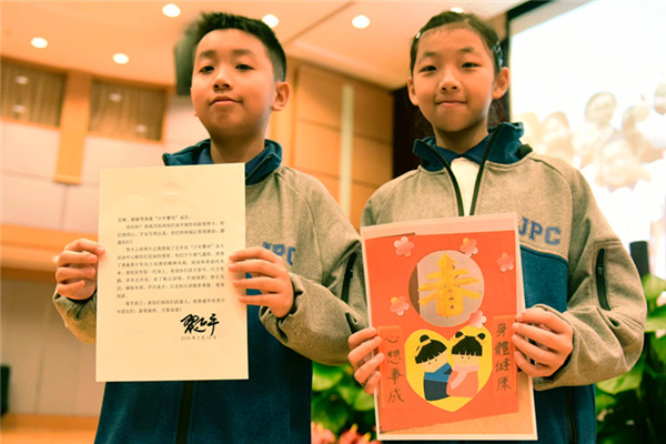 2月15日Au少年警訊v成員郭宏晞(左)展示習主席回信B羅顥凝(右)展示送給習主席的賀卡拼圖(圖G中新社)
