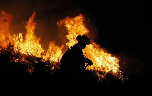 2018年8月9日A在美國加利福尼亞州埃爾西諾湖地區A一名消防員在山火現場工作C新華社記者李穎攝