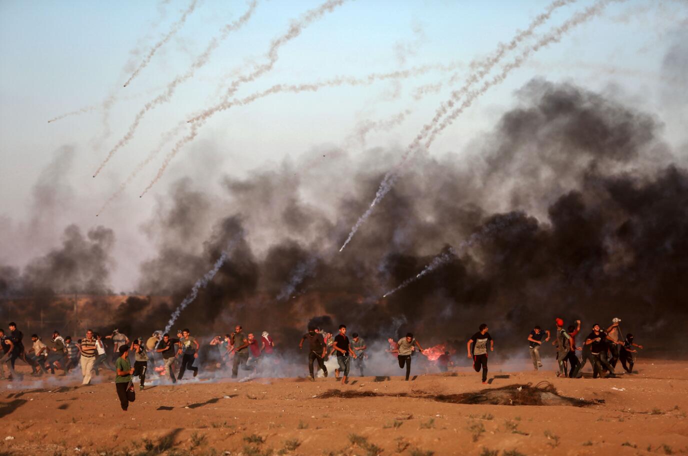 2018年8月10日A在加沙地帶邊境A巴勒斯坦人與以色列士兵衝突時躲避催淚瓦斯C新華社發