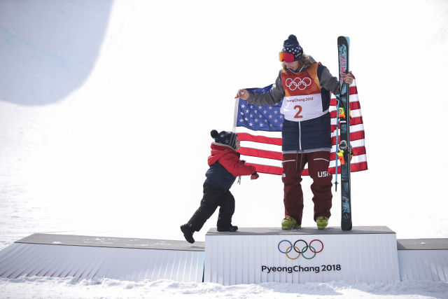 2018年2月22日A美國選手戴維P懷斯與自己的孩子在頒獎台上C當日A2018年平昌冬奧會自由式滑雪男子U型場地技巧決賽在鳳凰雪上公園舉行C美國選手戴維P懷斯以97.20分的成績獲得冠軍C 新華社記者費茂華攝