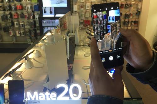 華為圖為顧客在一家電子用品商場體驗華為手機拍照功能C