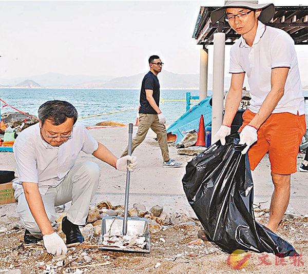 ■中聯辦員工在新界銀線灣海灘幫助清理「山竹」造成的雜物垃圾（香港文匯報）