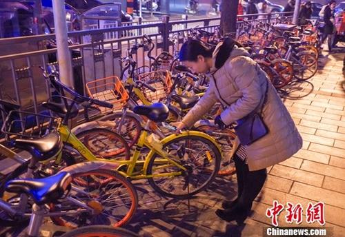 一女子在北京街頭掃碼使用ofo小黃車C中新社