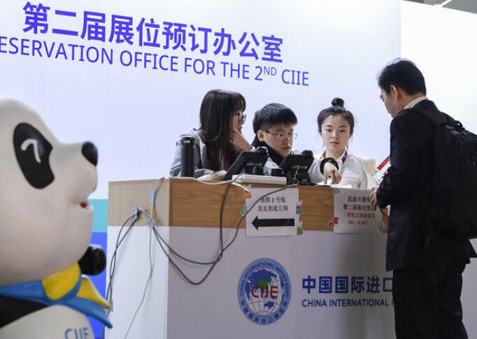 在第二屆中國國際進口博覽會展位預訂辦公室A一名來自馬來西亞的客商(右一)申請預訂展位(2018年11月10日攝)C新華社記者 李賀 攝