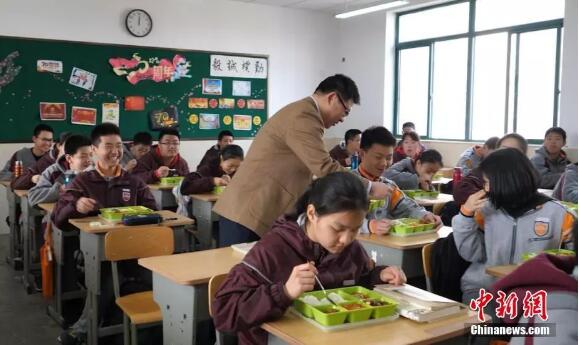 南京鍾英中學的校長走進教室與學生一起吃中飯C