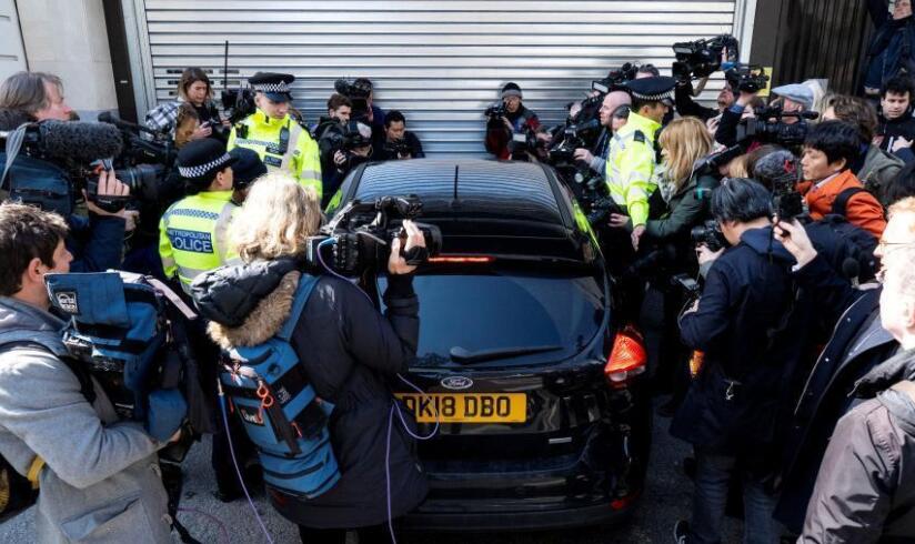 眾多媒體人士圍繞在一輛駛抵倫敦威斯敏斯特法院的警車旁C