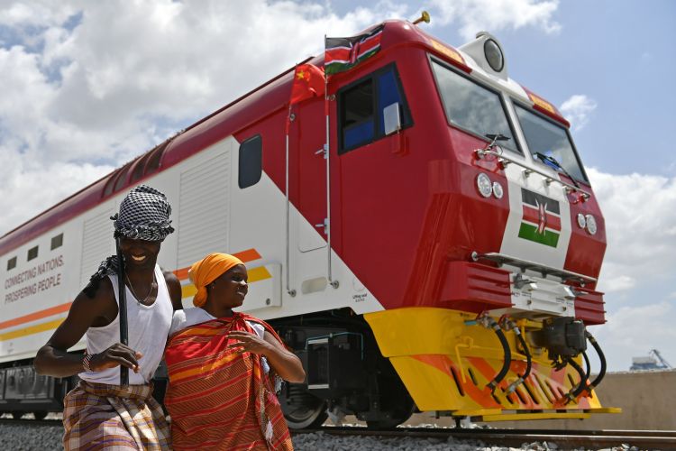 2017年1月11日A在肯尼亞蒙巴薩A當地民眾在中國承製的蒙內鐵路首批內燃機車旁載歌載舞C蒙內鐵路是肯尼亞自獨立以來最大的基礎設施工程A項目累計為當地直接創造逾4.6萬個工作崗位C新華社記者孫瑞博攝
