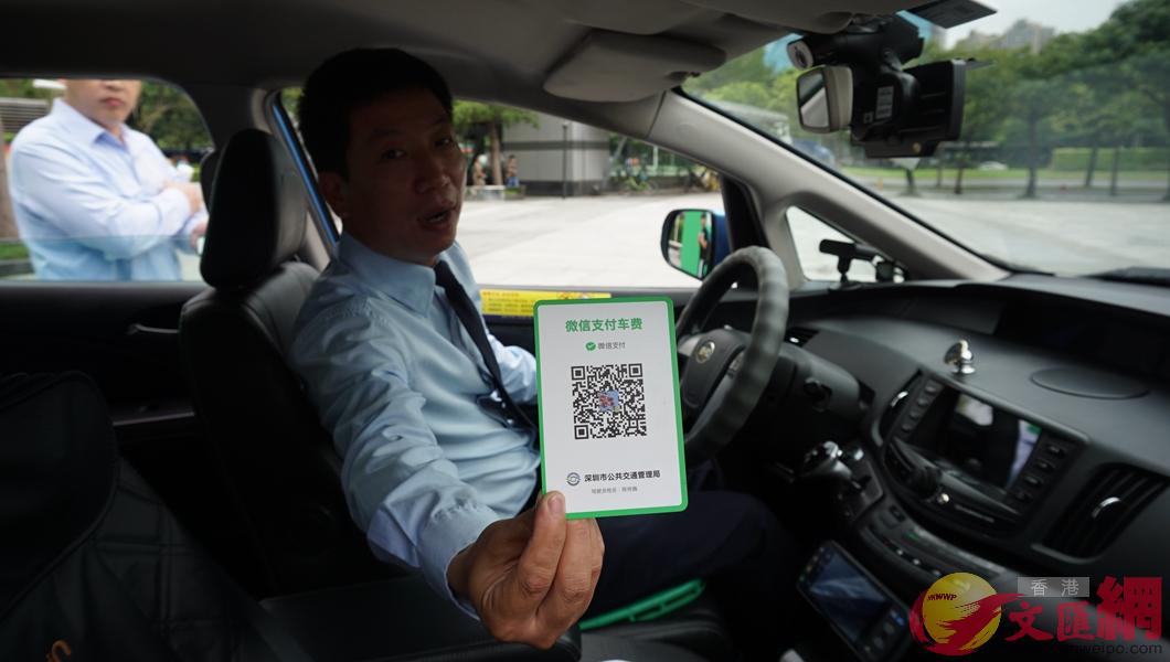 的士司機向記者展示正規的微信支付卡]記者 郭若溪攝^