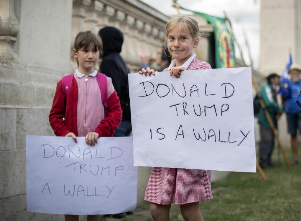兩名女孩手持標語抗議特朗普]美聯社^