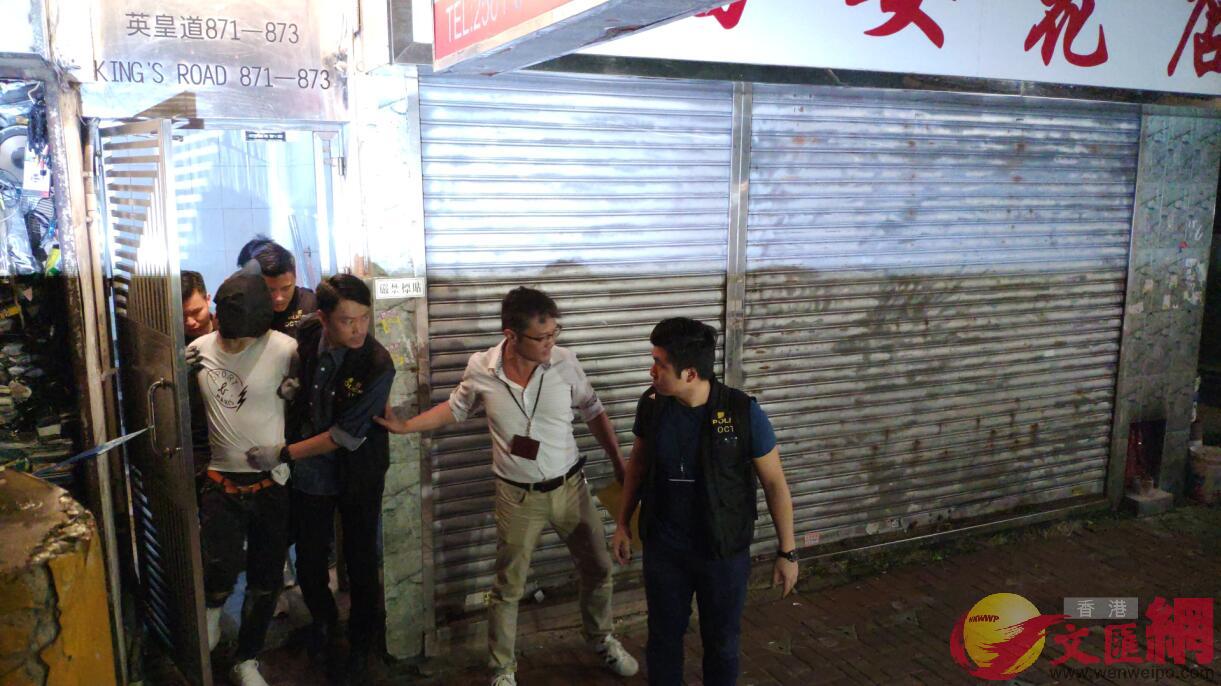警方押解疑犯從英皇道871-873號麗華樓一個單位離開 全媒體記者劉洋攝