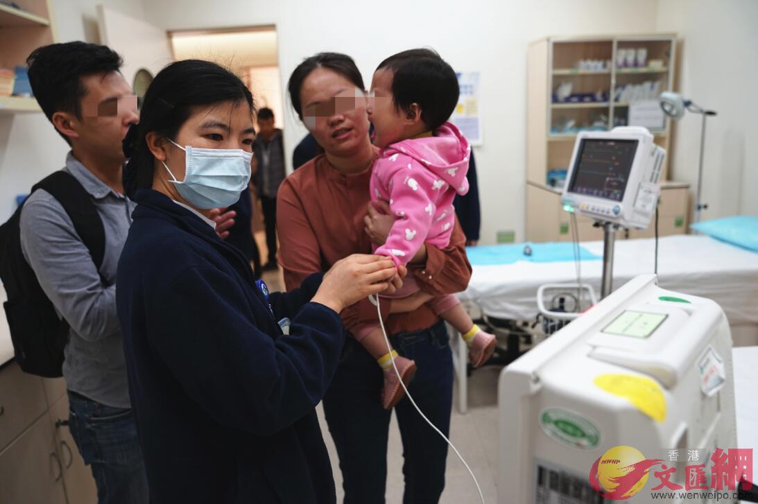 第八屆唇顎裂公益行動中香港大學深圳醫院鄒錫權醫生為患兒做檢查C]記者 郭若溪 攝^