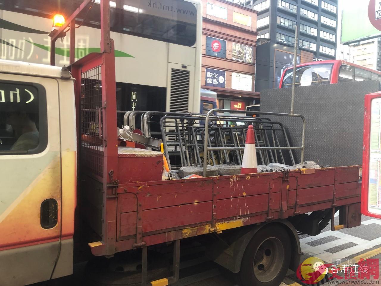 工作人員將巴士站隔離欄B隔離樁搬上卡車(全媒體記者蘇鉅祖攝)