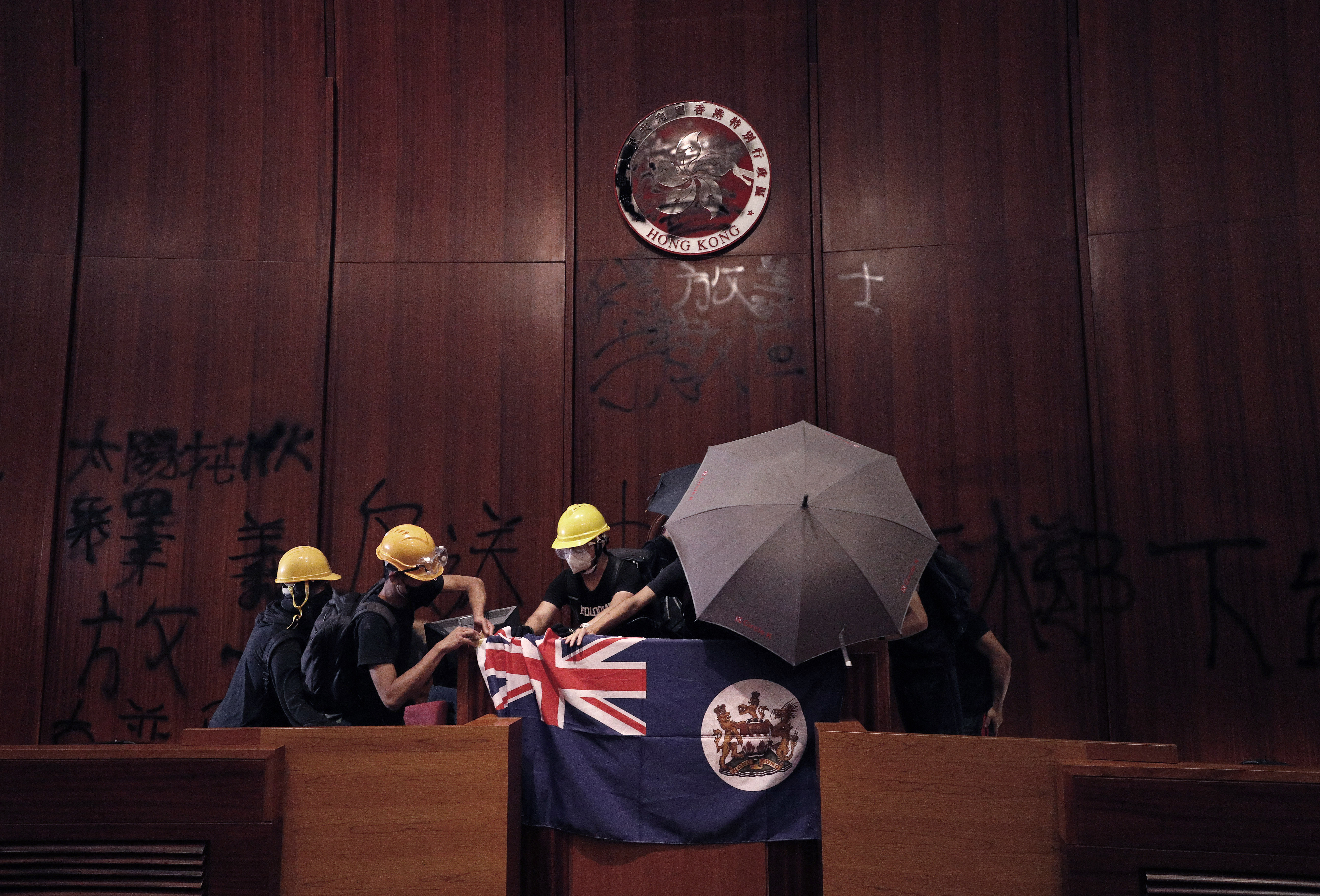 ■暴徒在立法會大肆塗 鴉，並在主席台上擺上港英旗。 資料圖片