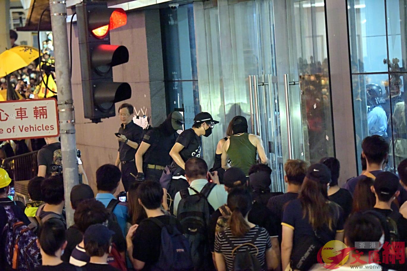 楊逸朗（綠色背心）在6月26日晚疑嘗試衝擊警總玻璃門。資料圖片