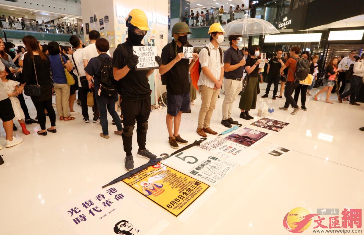 示威者以揚聲器呼籲市民加入罷工A又帶領在場市民叫u光復香港B時代革命v的口號C商場的服務台亦被貼上大量便利貼C 香港文匯報記者攝