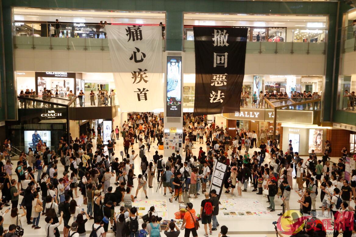 示威者以揚聲器呼籲市民加入罷工A又帶領在場市民叫u光復香港B時代革命v的口號C商場的服務台亦被貼上大量便利貼C 香港文匯報記者攝