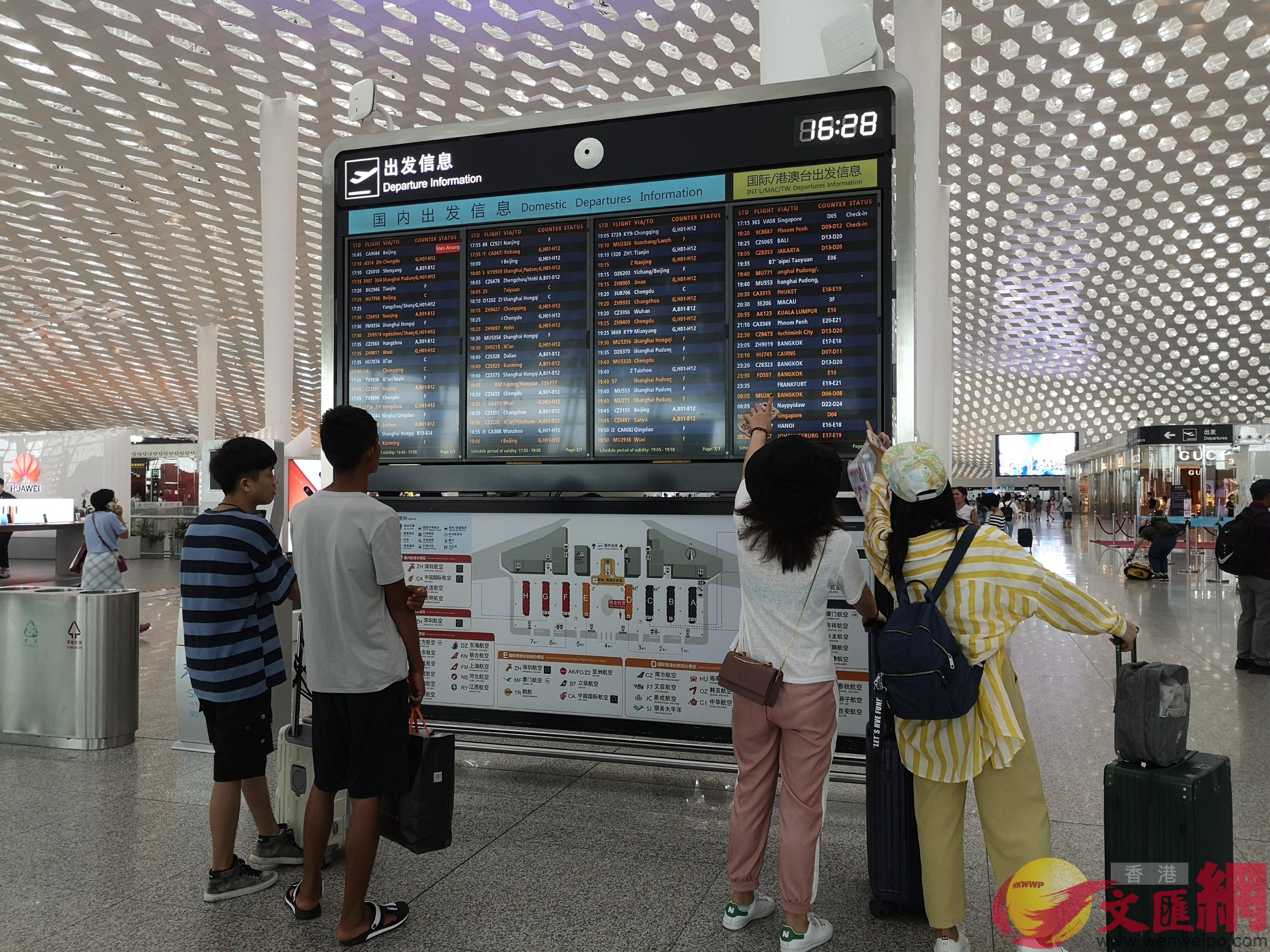 旅客在深圳機場航班信息前查看航班動態 ]記者郭若溪攝^