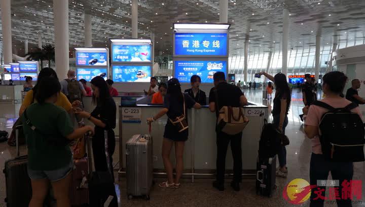 深圳機場跨境巴士購票台前圍滿了購買返港車票的旅客]記者 郭若溪攝^