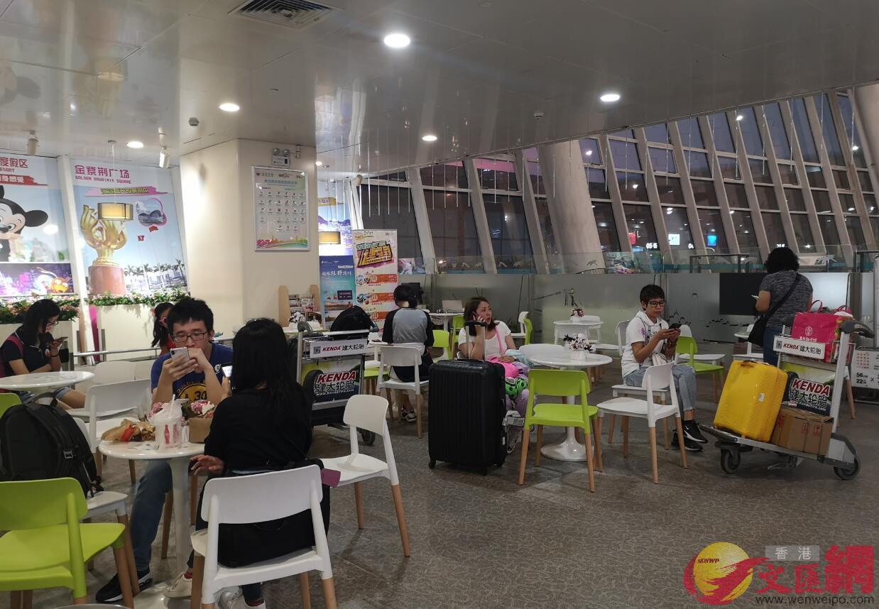 深港機場中轉旅客休息區坐滿了等待返港的旅客]記者 郭若溪攝^