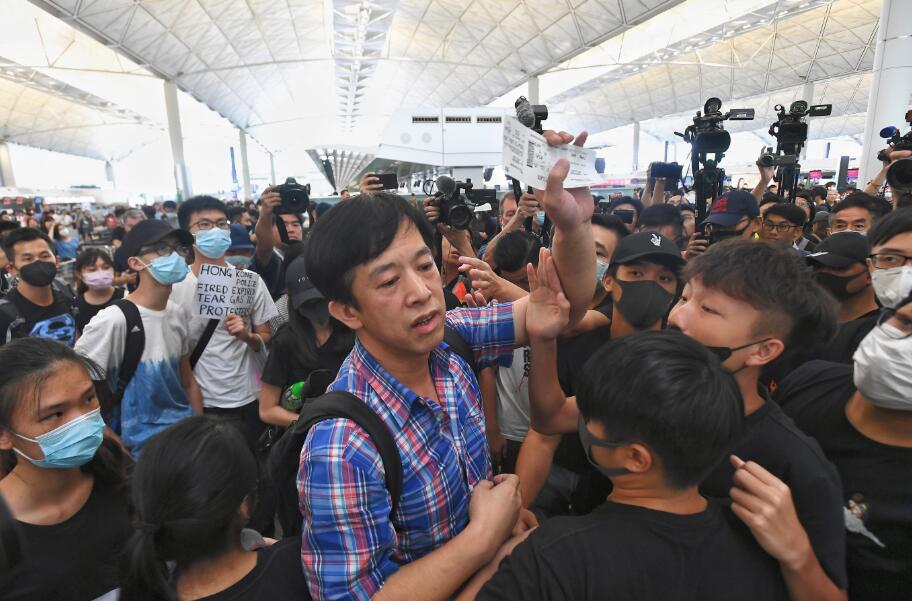 8月13日下午A大批示威者以機場手推車等堵塞1號客運大樓旅客登機行段及保安閘門C有旅客欲經1號客運大樓保安閘口進入離境大堂A期間遭示威者阻撓指罵C 香港中通社