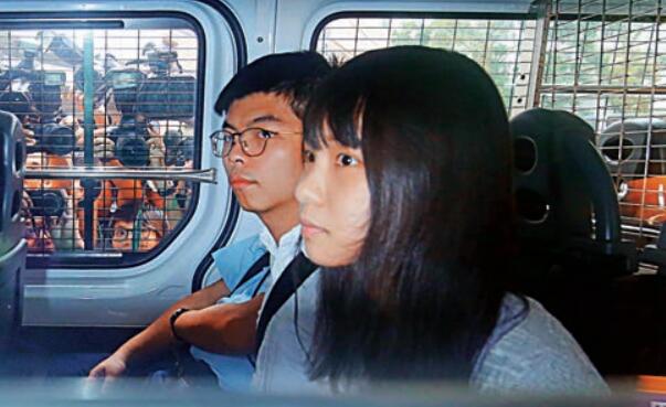 香港眾志秘書長黃之鋒與成員周庭昨日涉 u煽惑他人非法集結v 被拘提堂C 大公報記者攝 