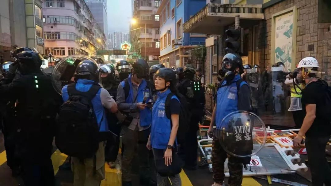 身穿藍色背心香港警察傳媒聯絡隊成員